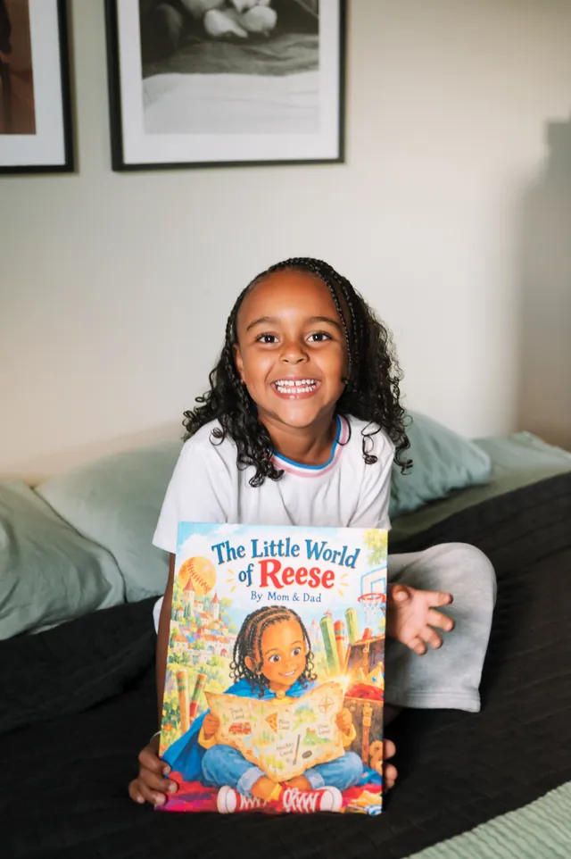 Reese smiling with her printed The Little World of Reese storybook