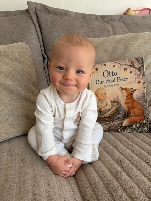 A smiling baby beside their personalized Otto, Our Final Piece storybook
