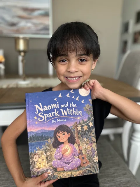 A smiling child holding Naomi and the Spark Within