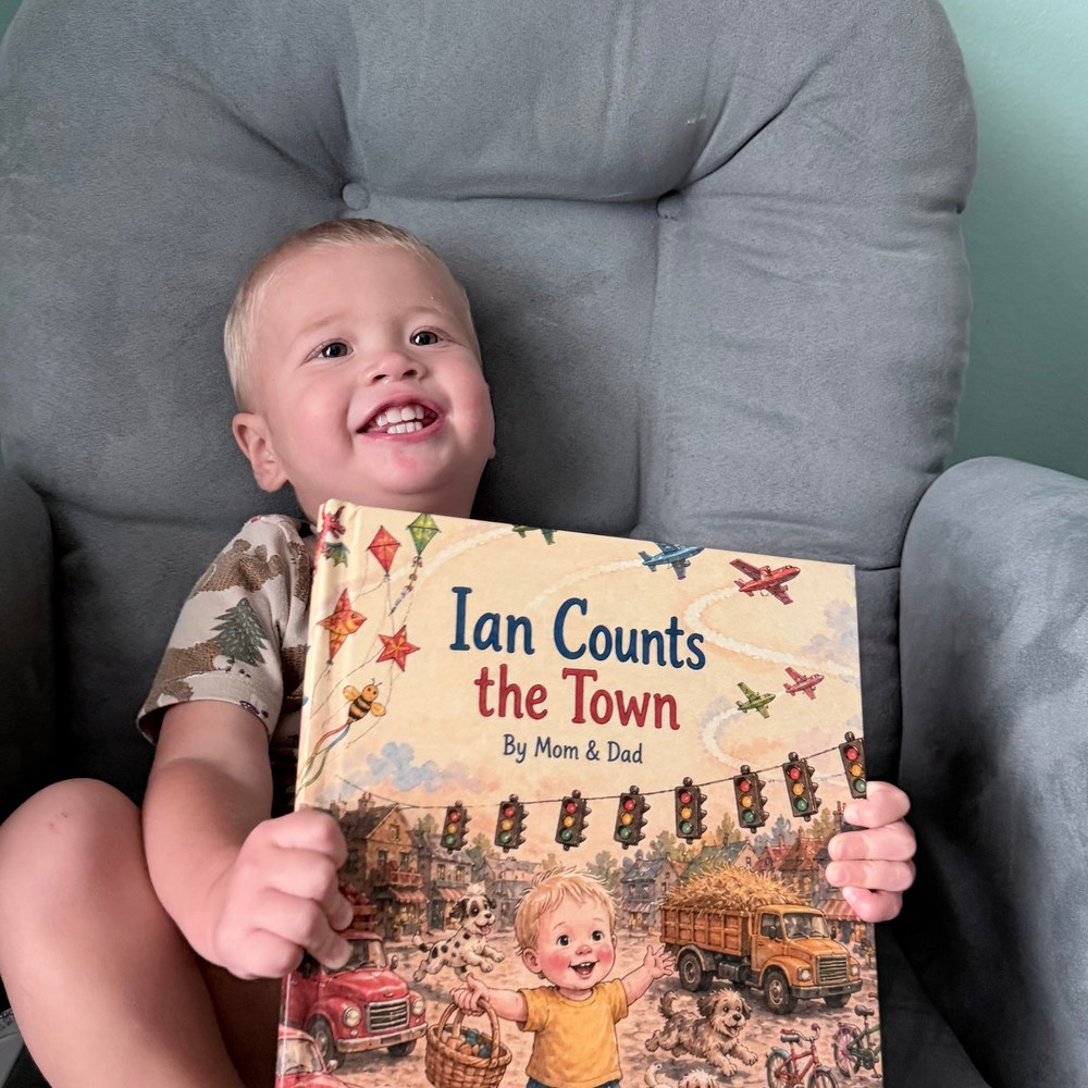 Ian laughing while holding his printed Ian Counts the Town book, with his name and illustrated likeness visible on the cover