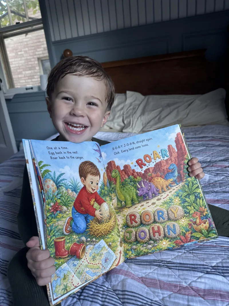 A child holding open his printed Sundayfawn dinosaur book, showing the story text and illustrated spread.