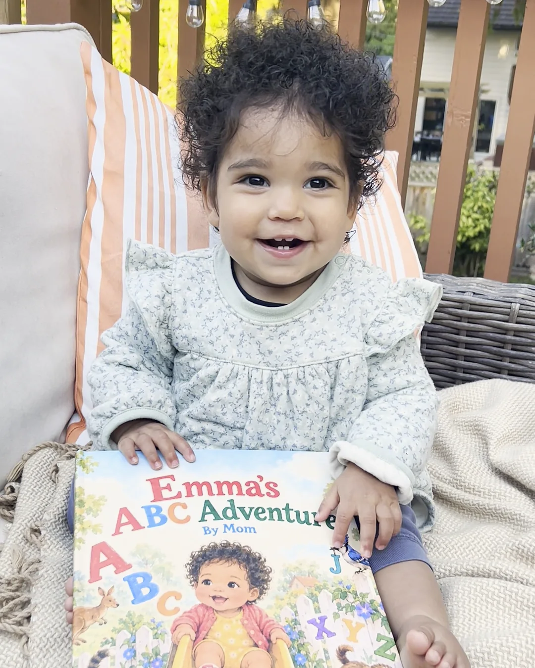 Emma smiling with her personalized Emma’s ABC Adventure storybook.