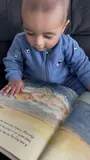 Vihaan exploring the illustrations inside his personalized newborn storybook.