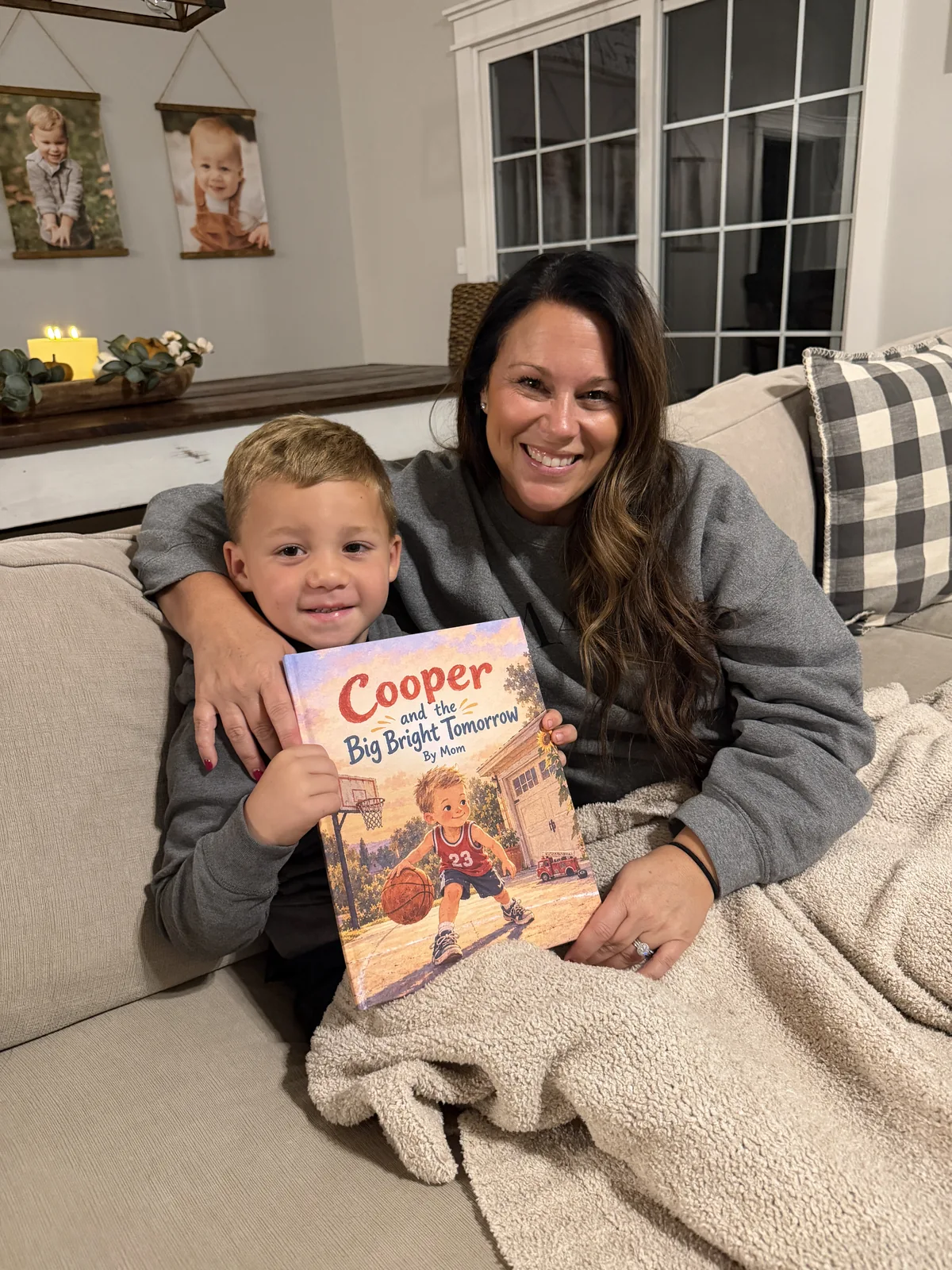 Cooper and his parent smiling while holding Cooper and the Big Bright Tomorrow.
