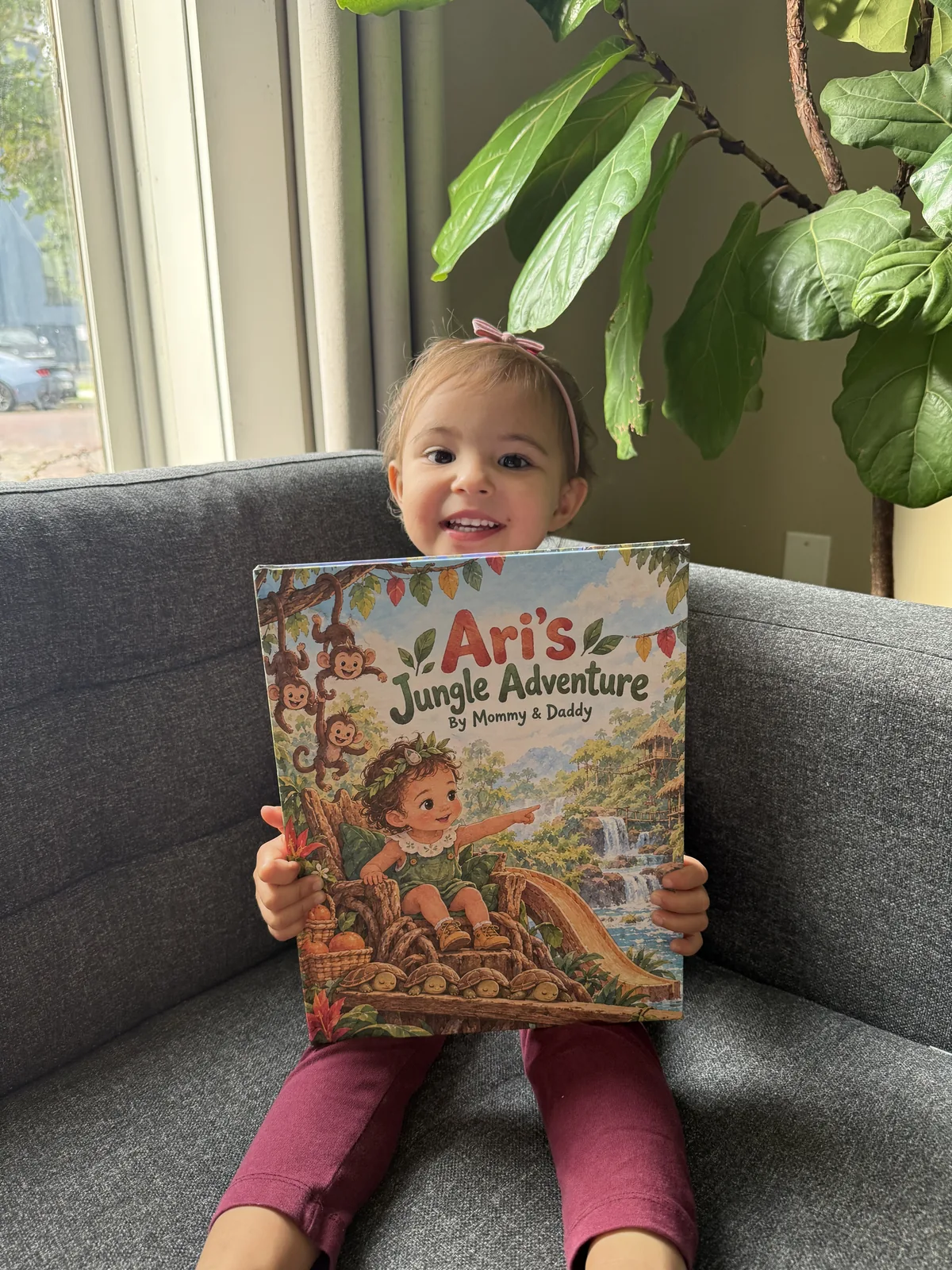 Ari smiling while holding her personalized jungle storybook.
