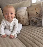 Otto smiling with the illustrated pages of his Sundayfawn storybook open.
