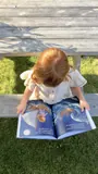 Camila looking at the illustrated pages of her personalized lost stuffie storybook.