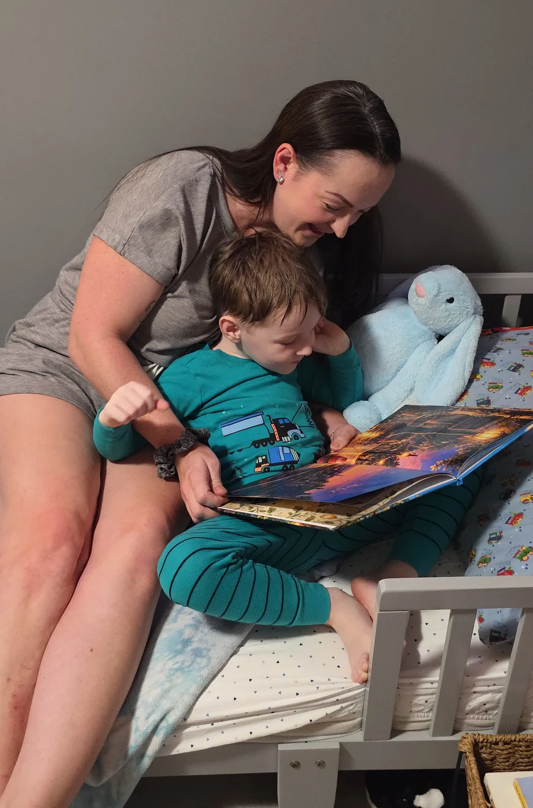 Riley reading his personalized train book with his parent.