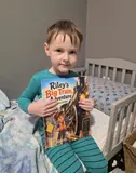 Riley holding his personalized train storybook.
